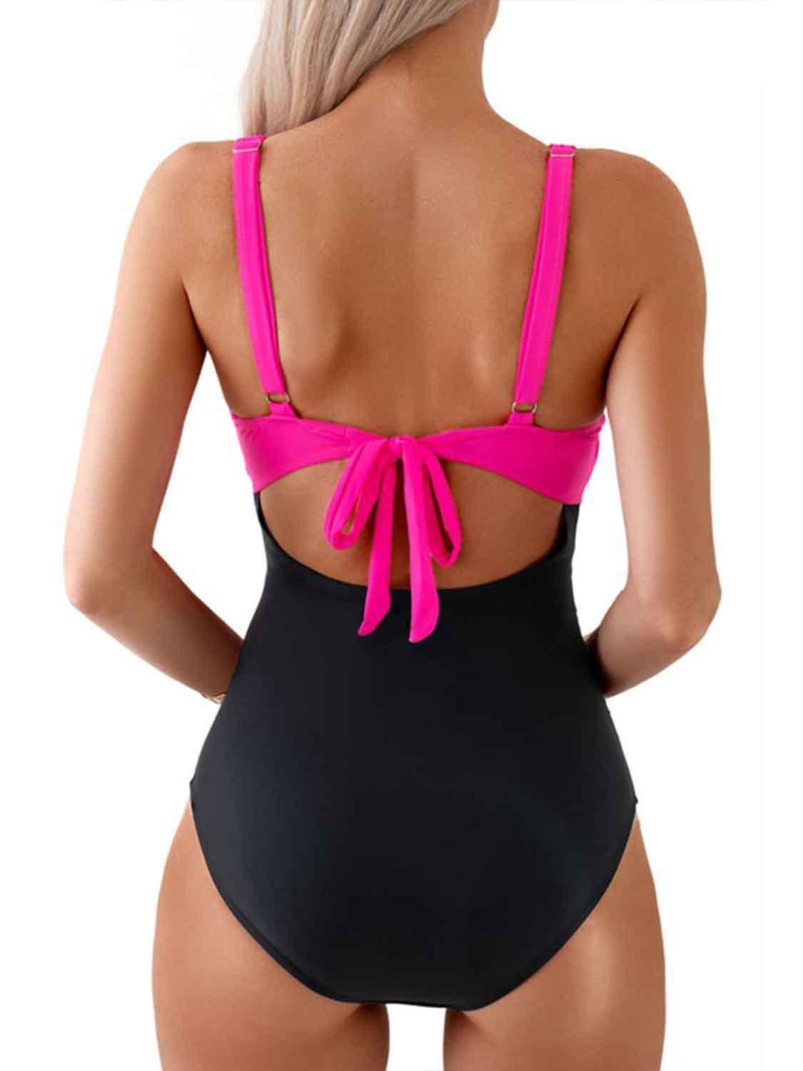 a woman wearing a black and pink one piece swimsuit