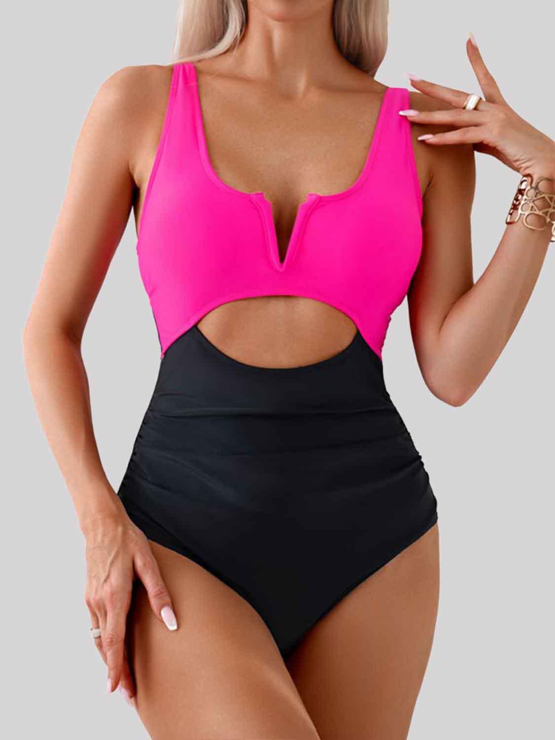 a woman in a pink and black one piece swimsuit