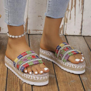 a woman's feet wearing a pair of colorful sandals