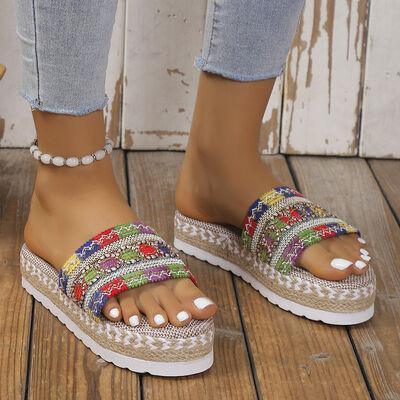a woman's feet wearing a pair of colorful sandals