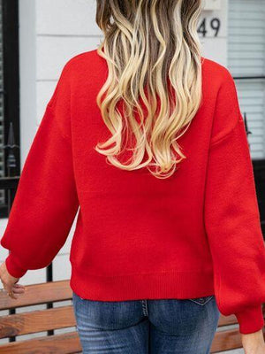 a woman wearing a red sweater and jeans
