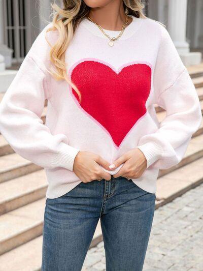 a woman wearing a white sweater with a red heart on it