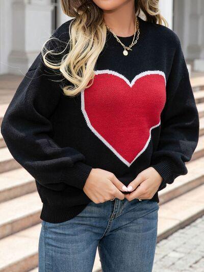 a woman wearing a black sweater with a red heart on it