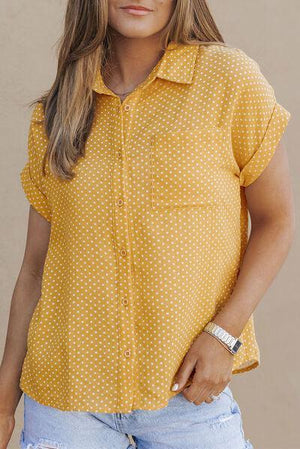 a woman wearing a yellow polka dot shirt