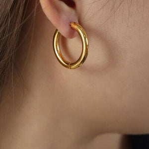 a close up of a person wearing a pair of earrings