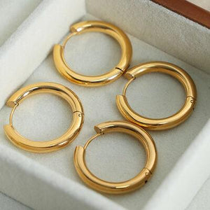 three pairs of gold hoop earrings in a box