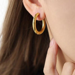 a close up of a person wearing a pair of earrings