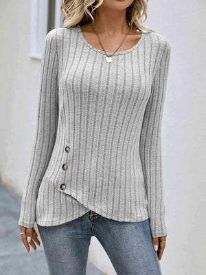 a woman wearing a gray sweater and jeans