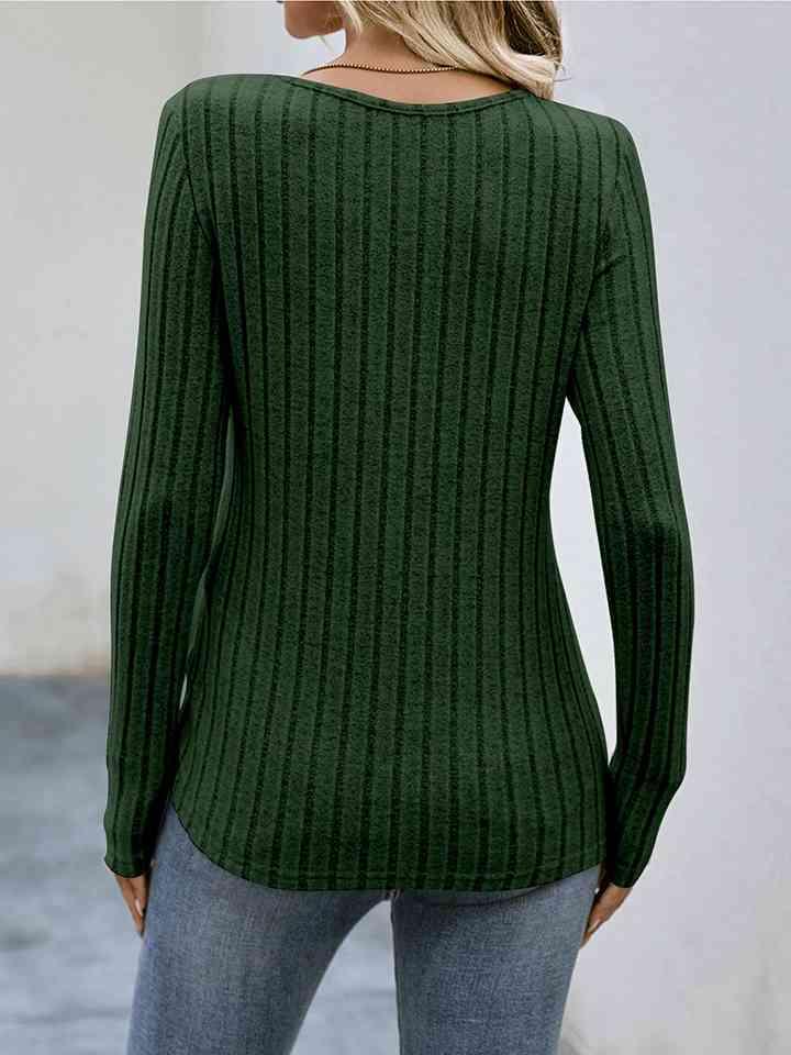 a woman wearing a green sweater and jeans