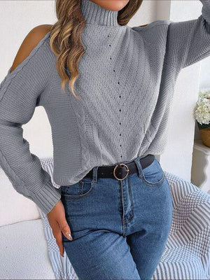 a woman wearing a gray sweater and jeans