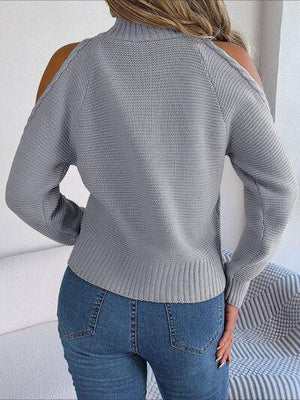 a woman wearing a grey sweater and jeans