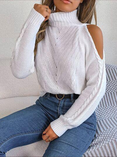 a woman sitting on a couch wearing a white sweater and jeans