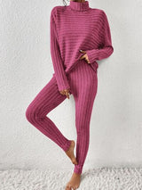 a woman wearing a pink sweater and pants