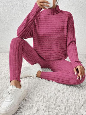 a woman in a pink turtle neck sweater and pants