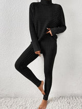 a woman wearing a black turtle neck sweater and leggings