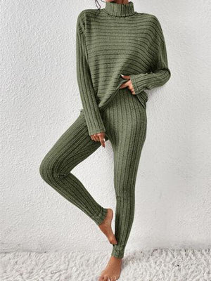 a woman wearing a green sweater and pants