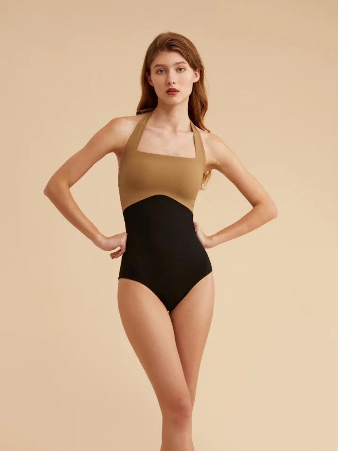 a woman in a black and tan one piece swimsuit