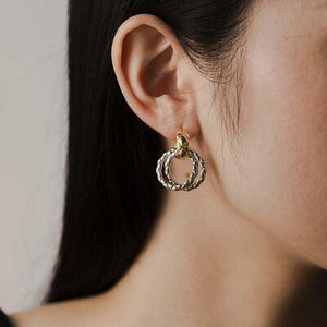 a close up of a person wearing a pair of earrings