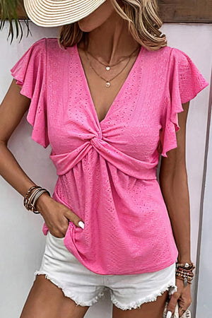 a woman wearing a pink top and white shorts