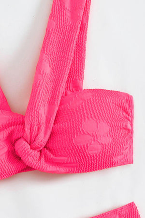 a close up of a pink bra with a knot on it