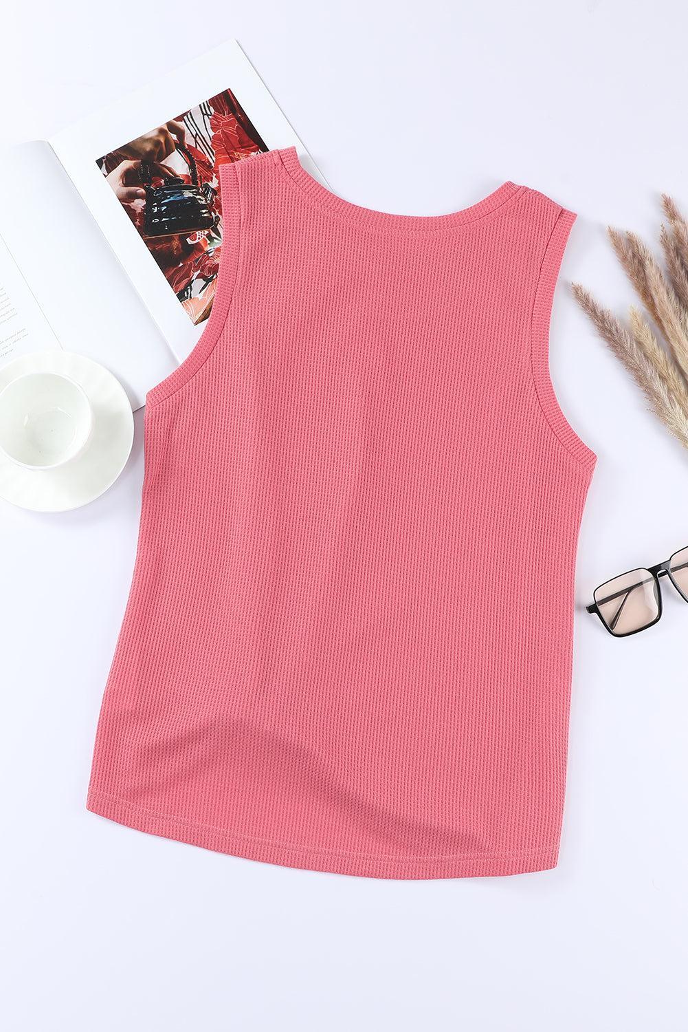 a pink tank top next to a pair of glasses