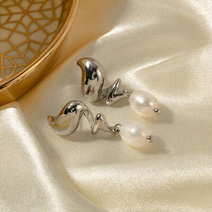 a pair of earrings sitting on top of a white cloth