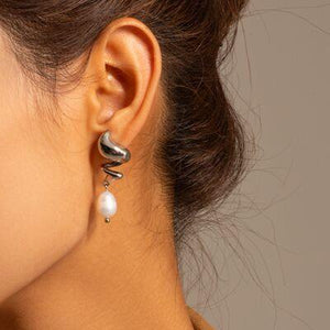 a close up of a person wearing a pair of earrings