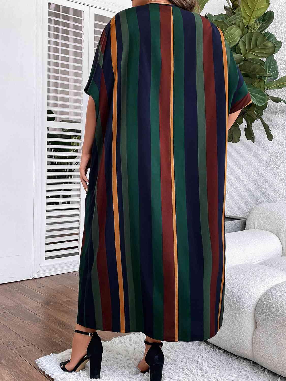 a woman standing in a living room wearing a striped dress
