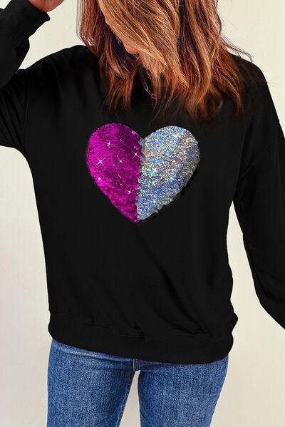 a woman wearing a black sweatshirt with a purple heart on it