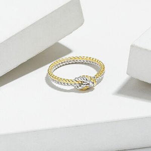 a gold and silver ring sitting on top of a white surface