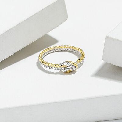 a gold and silver ring sitting on top of a white surface