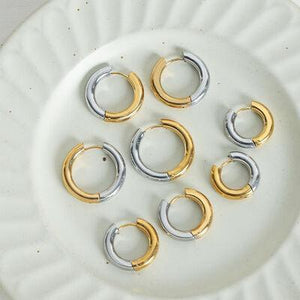 a white plate topped with lots of gold and silver rings