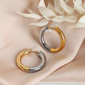 a pair of gold and silver hoop earrings