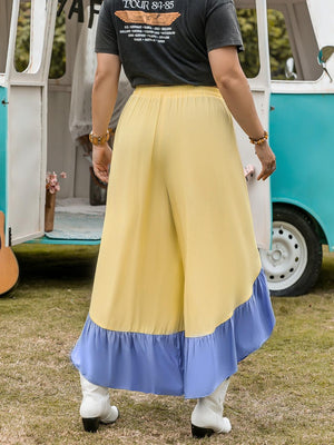 a woman standing in front of a blue and white bus