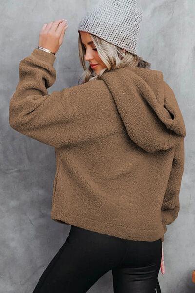 a woman in a brown sweater and black pants