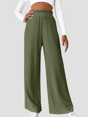 a woman in a white top and green pants