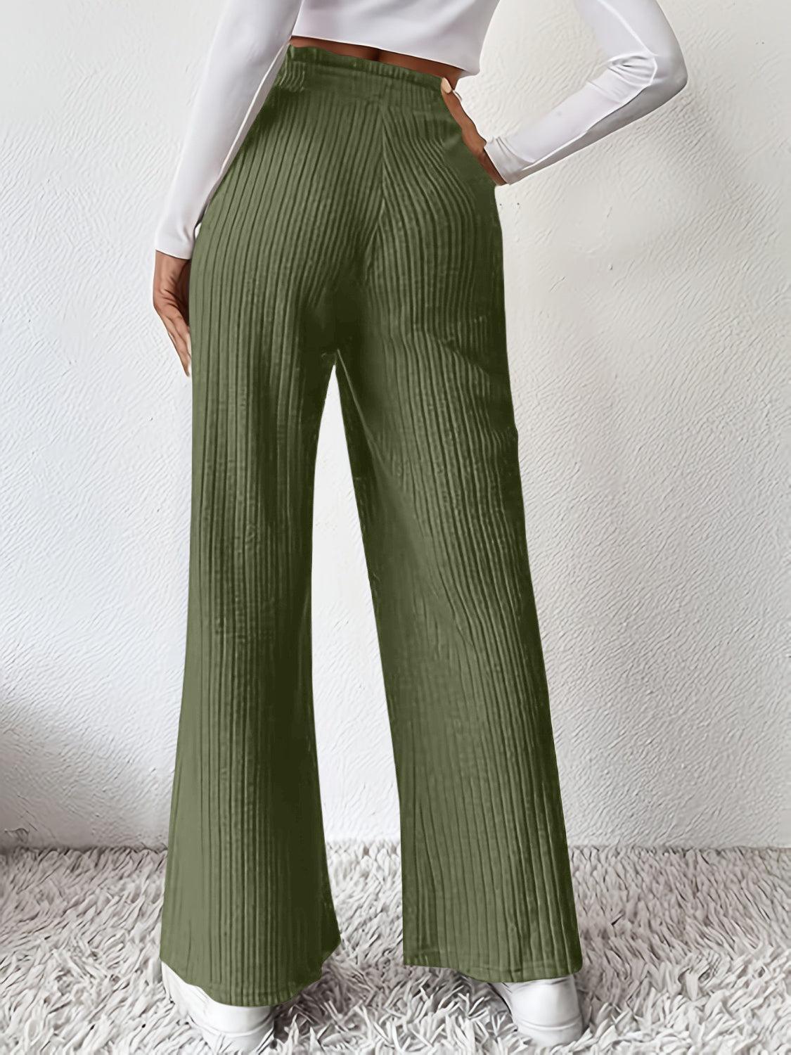 a woman in a white shirt and green pants