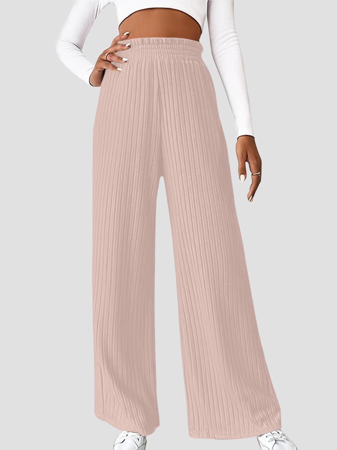 a woman in a white top and pink pants