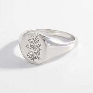 a silver signet ring with a tree on it