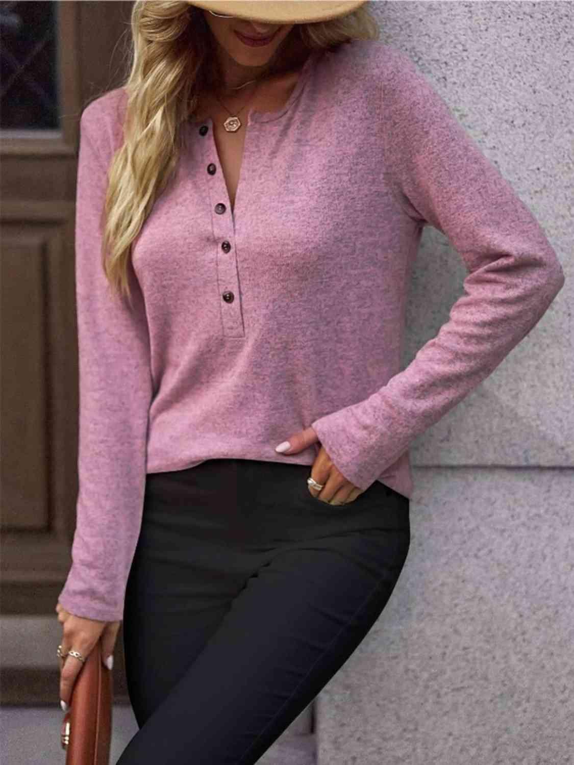 a woman wearing a pink sweater and black pants