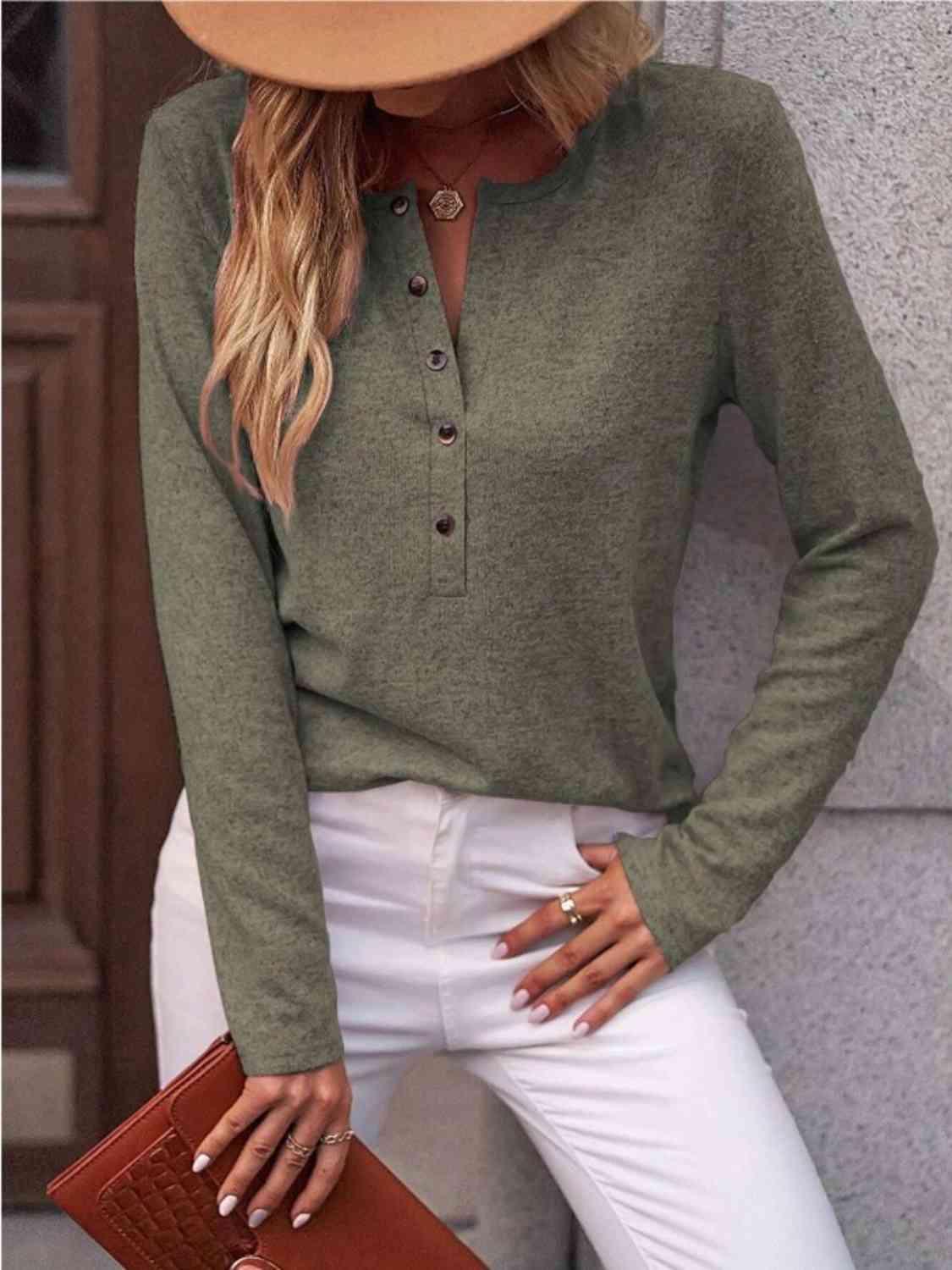 a woman wearing a green sweater and white pants