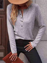 a woman wearing a gray shirt and black pants