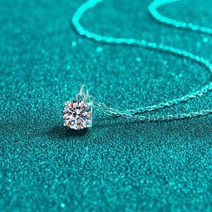 a necklace with a diamond on a blue surface