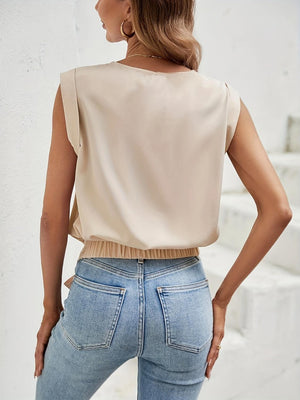 a woman wearing a beige top and jeans