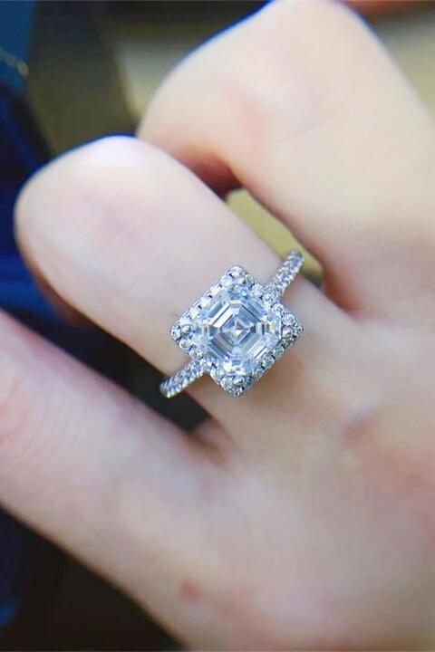 a close up of a person's hand with a diamond ring