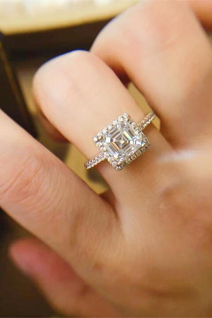 a close up of a person's hand with a diamond ring