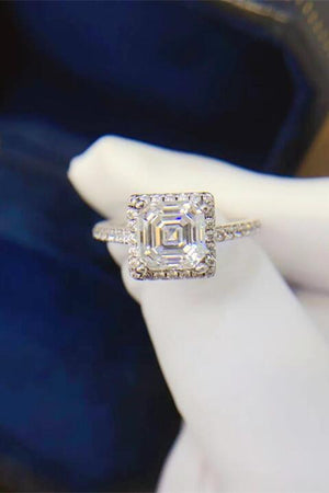 a woman's hand holding a diamond ring