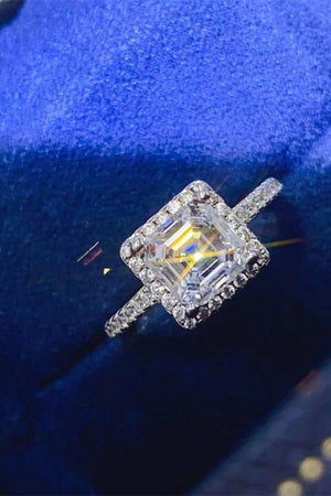 a diamond ring sitting on top of a blue velvet case