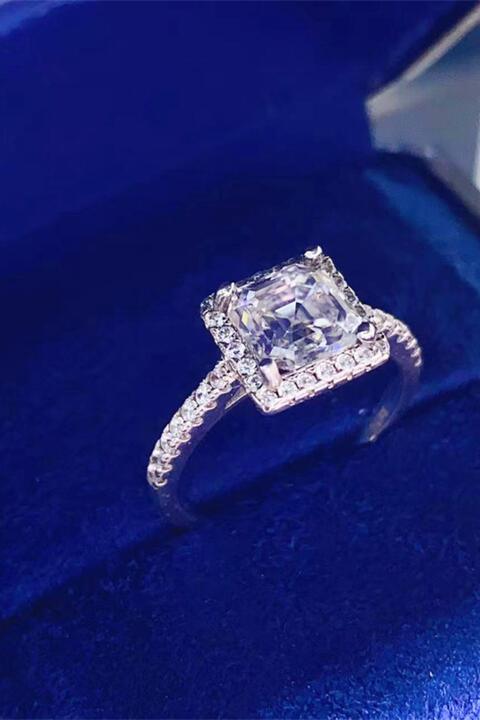 a diamond ring sitting on top of a blue velvet box