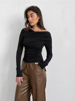 a woman wearing brown pants and a black top